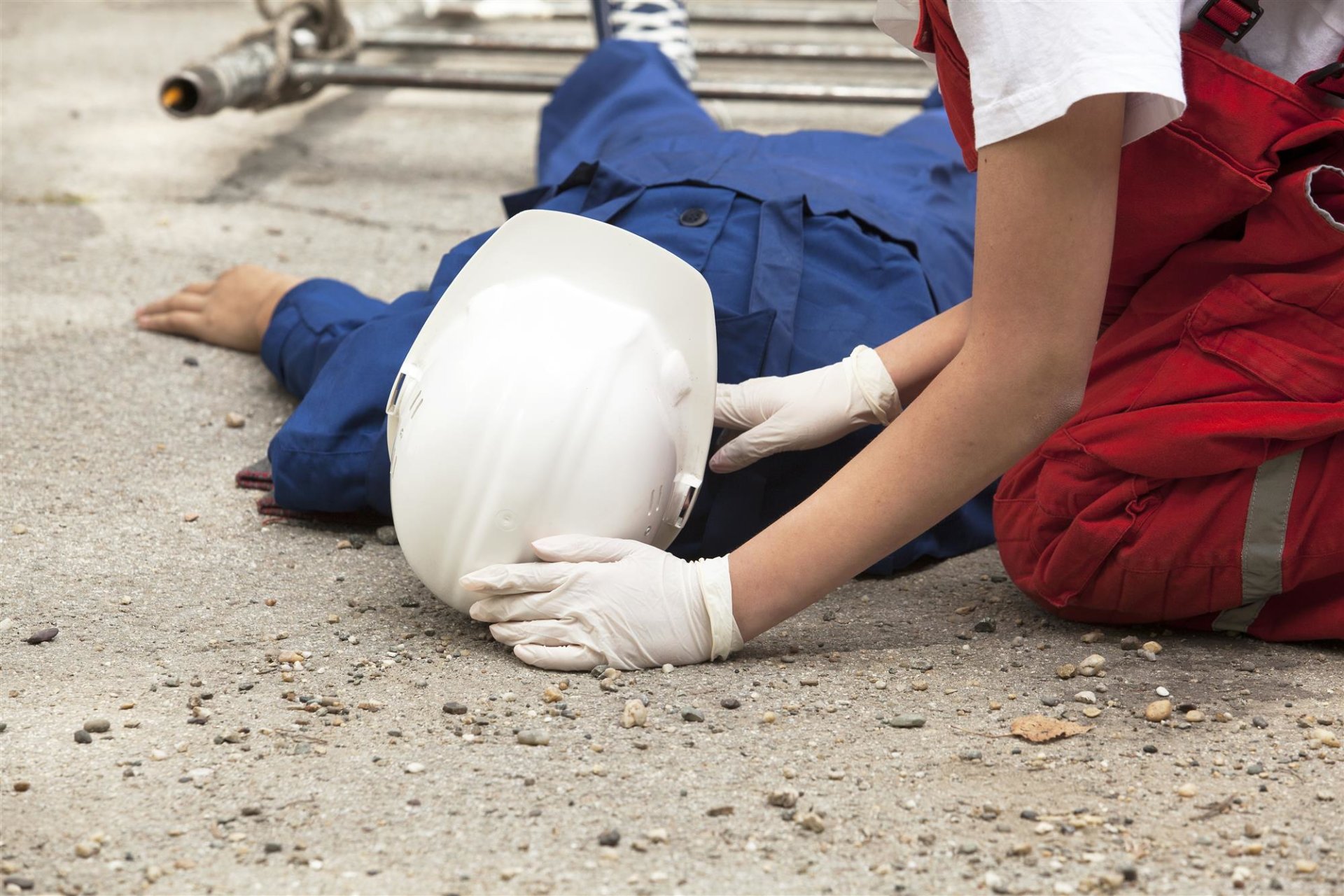 injured construction worker lying on his back and receiving care