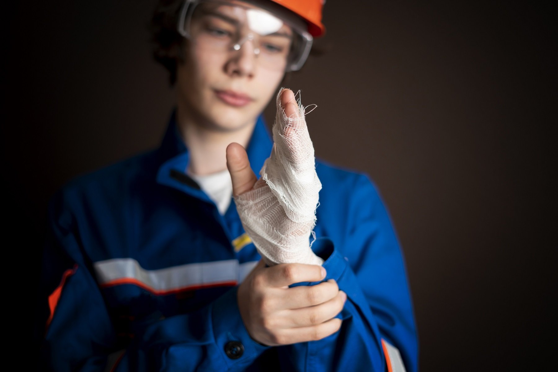 injured worker in uniform isolated on dark background