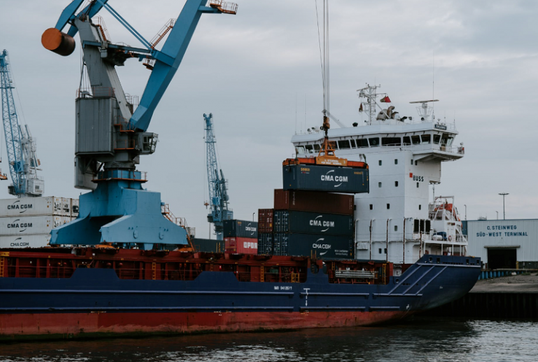 red and white cargo ship beside dock