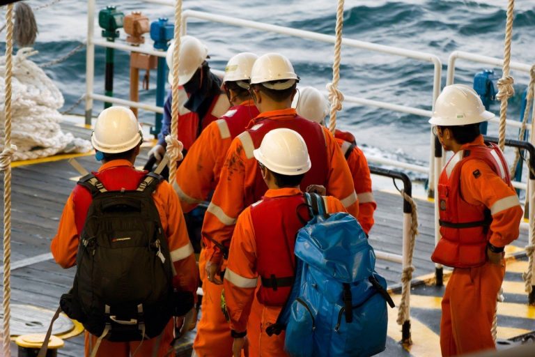 Rig workers using a swing rope prior of being transported to nearby rigs by boat