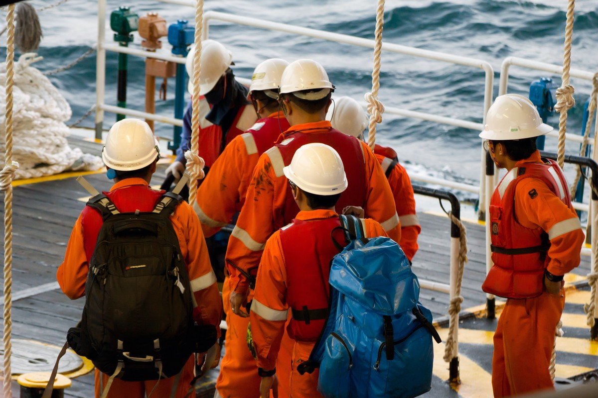 Rig workers using a swing rope prior of being transported to nearby rigs by boat