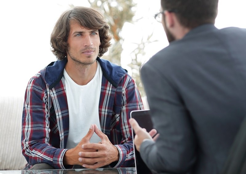 young man sitting on consultation with his lawyer