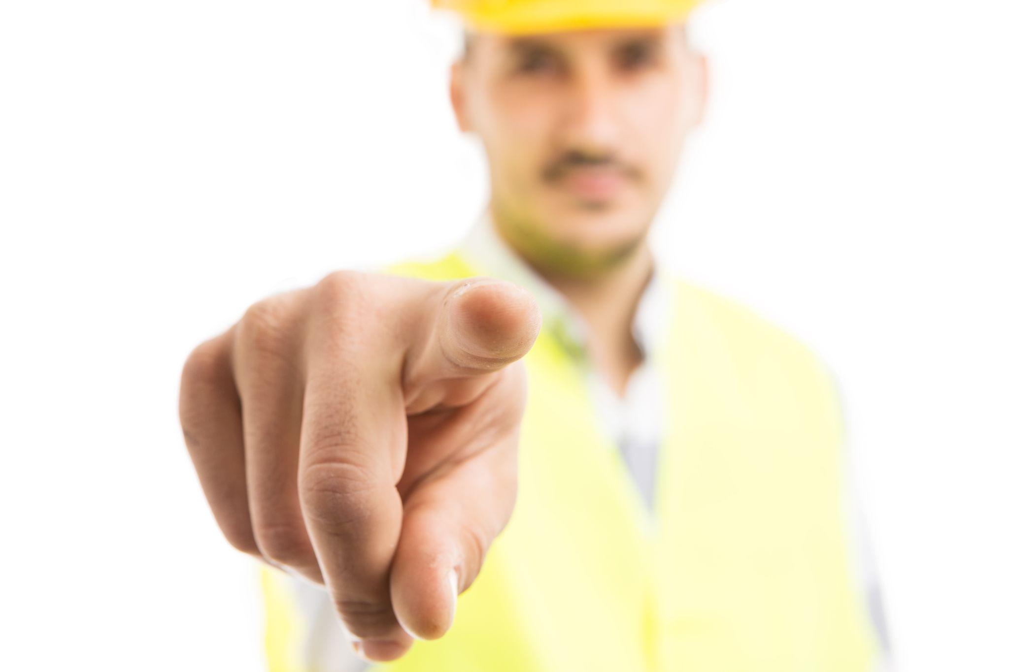 Building contractor pointing finger at camera