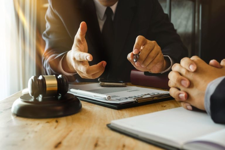 business people and lawyers discussing contract papers sitting at the table