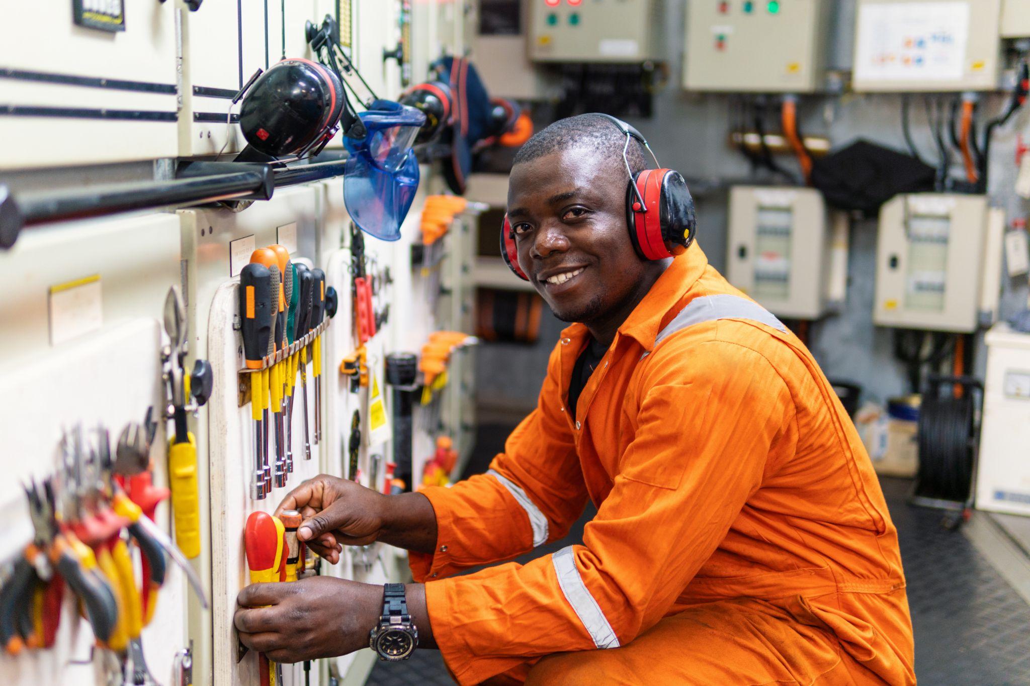 African marine engineer officer in engine control room ECR.