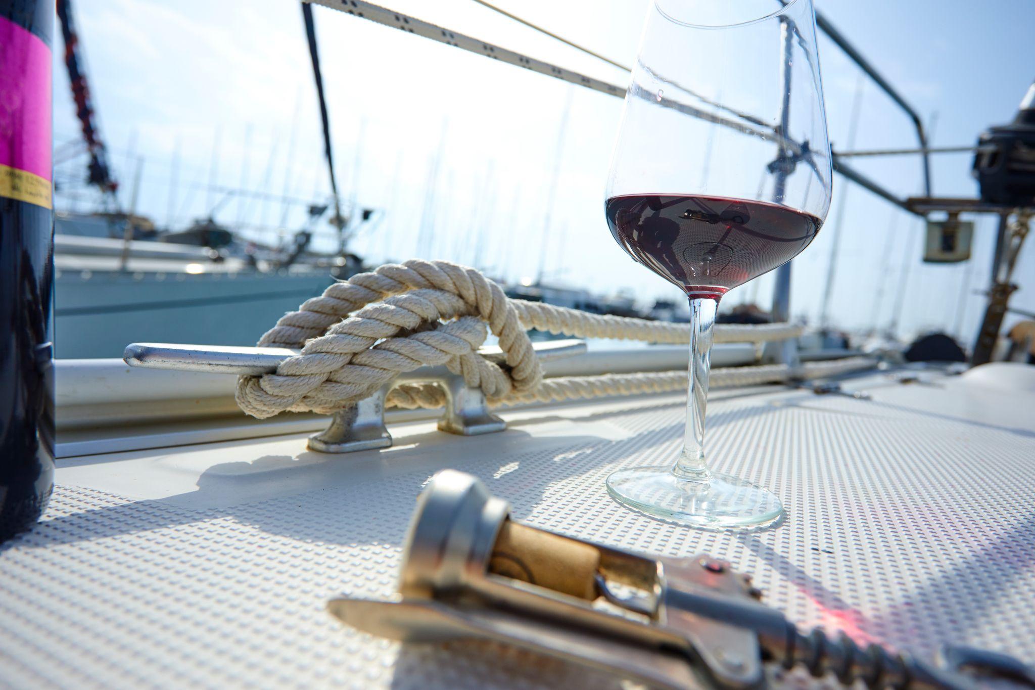 A glass of red wine on the deck of the yacht