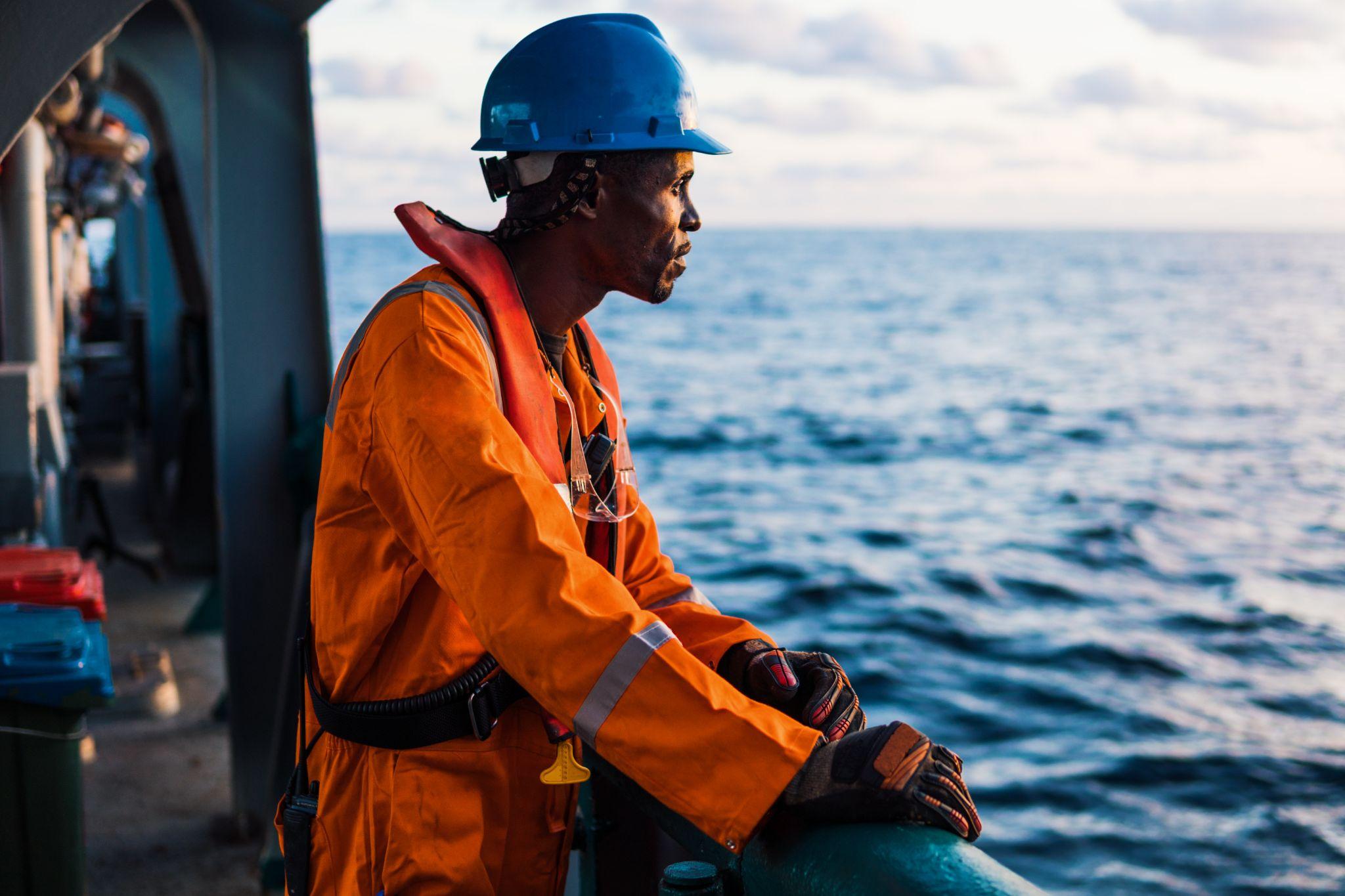 Seaman on deck of vessel or ship , wearing PPE personal protective equipment