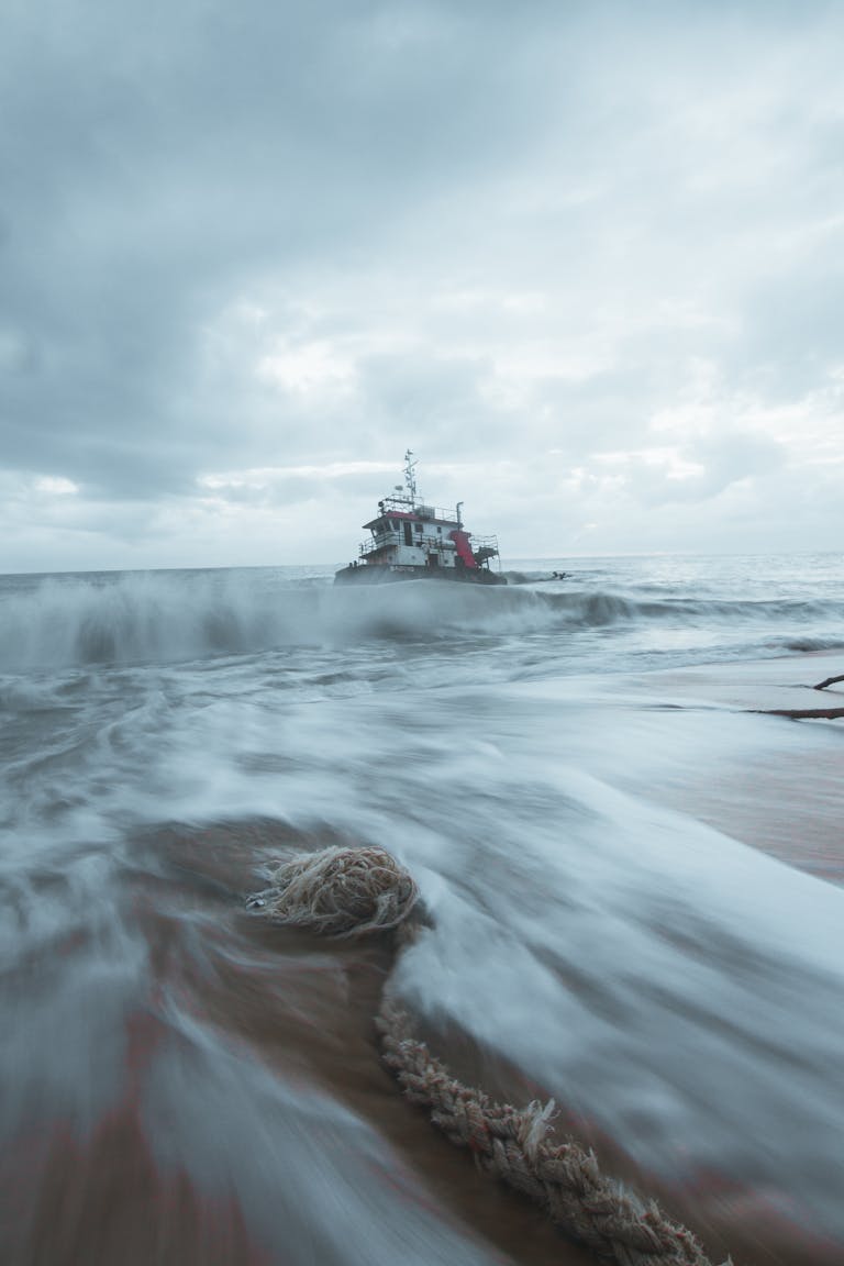 A boat is moving through the water on a beach