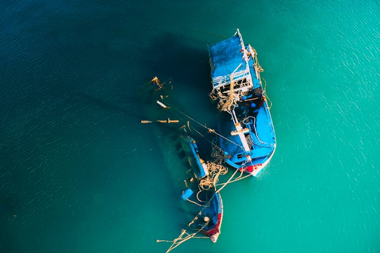 From above picturesque view of boats floating in ocean bright green water in daylight