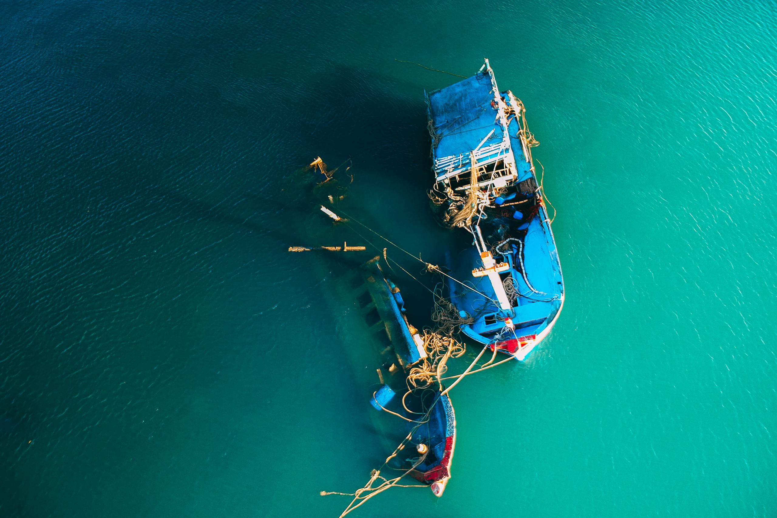 From above picturesque view of boats floating in ocean bright green water in daylight